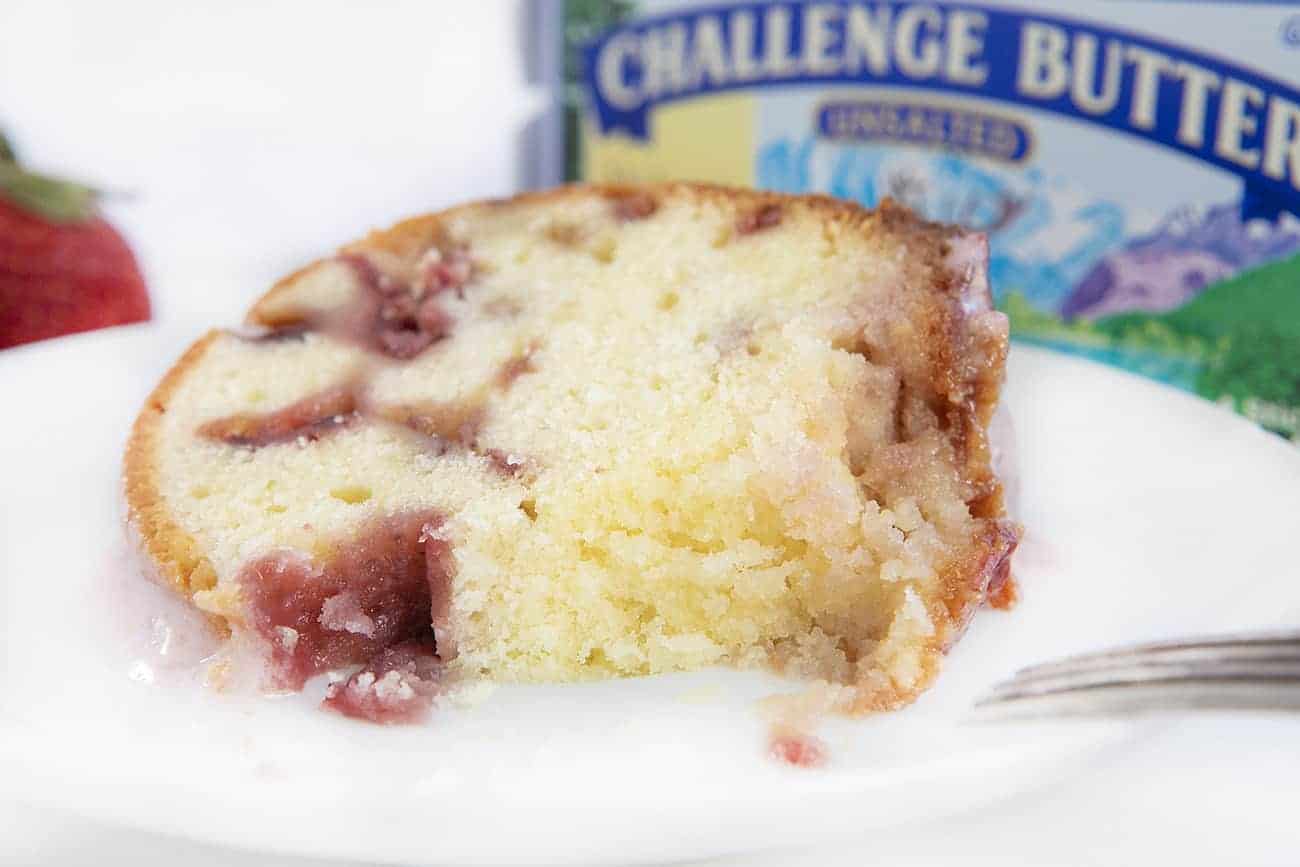 Slice of Strawberry Cream Cheese Pound Cake on a White Plate with Bite Missing