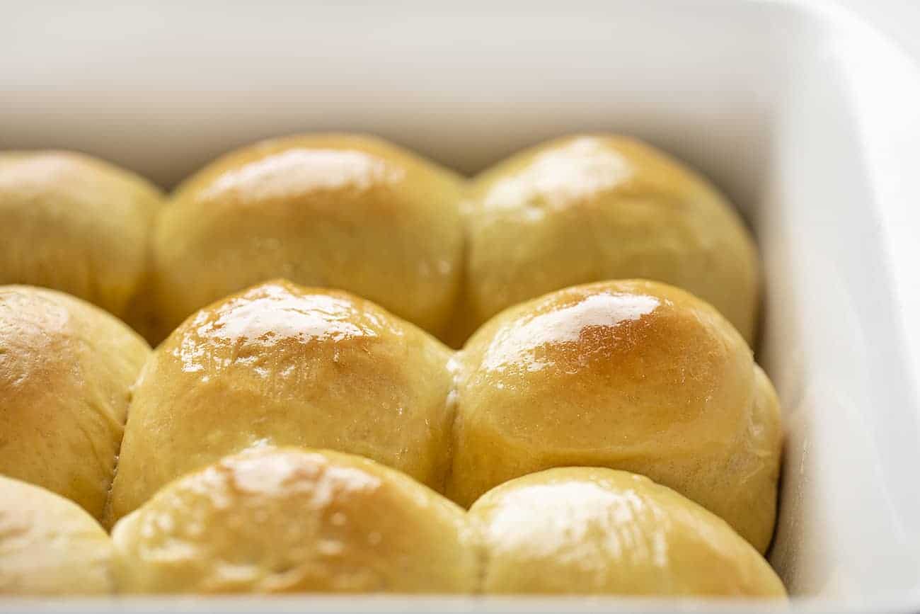 Side View of Pan of Baked Hawaiian Dinner Rolls with Butter