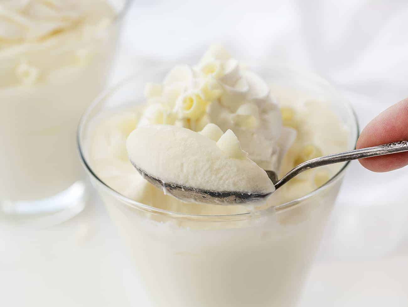 Spoonful of White Chocolate Mousse Being Lifted Out of Glass