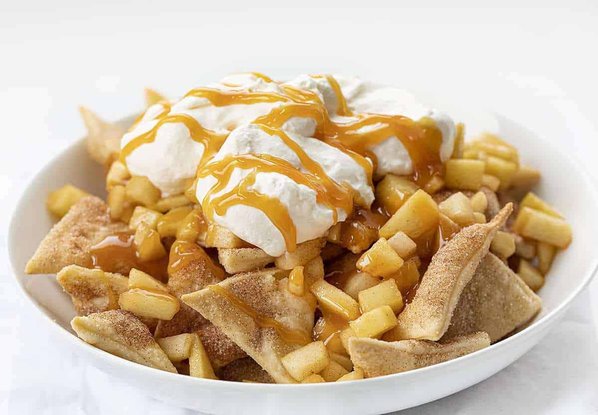 White Bowl of Apple Pie Nachos with Whipped Cream and Caramel Sauce