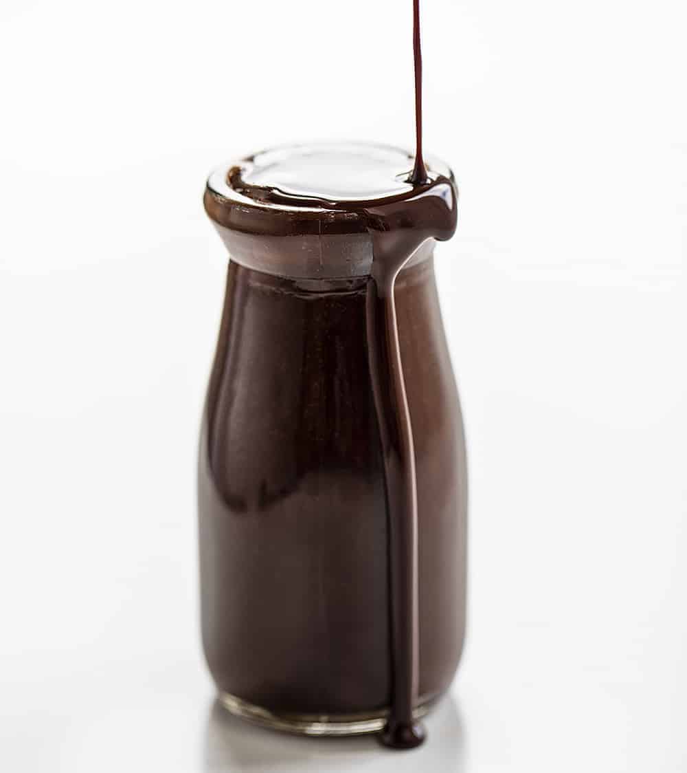 Pouring Chocolate Syrup into Jar and it Spilling Over Edge