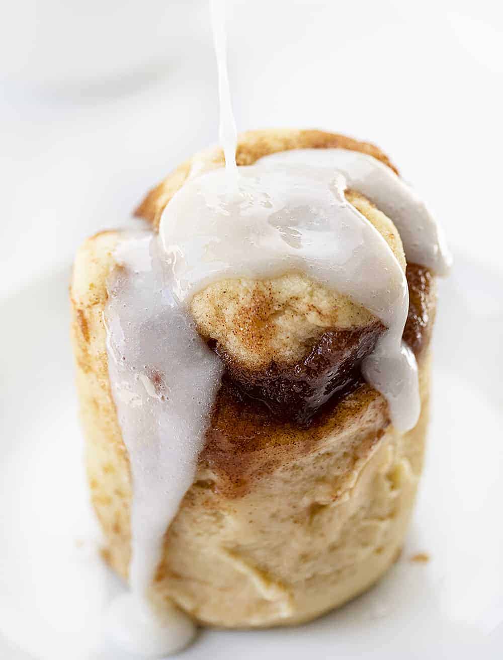 Pouring Glaze over a Cinnamon Roll that was microwaved in a Mug