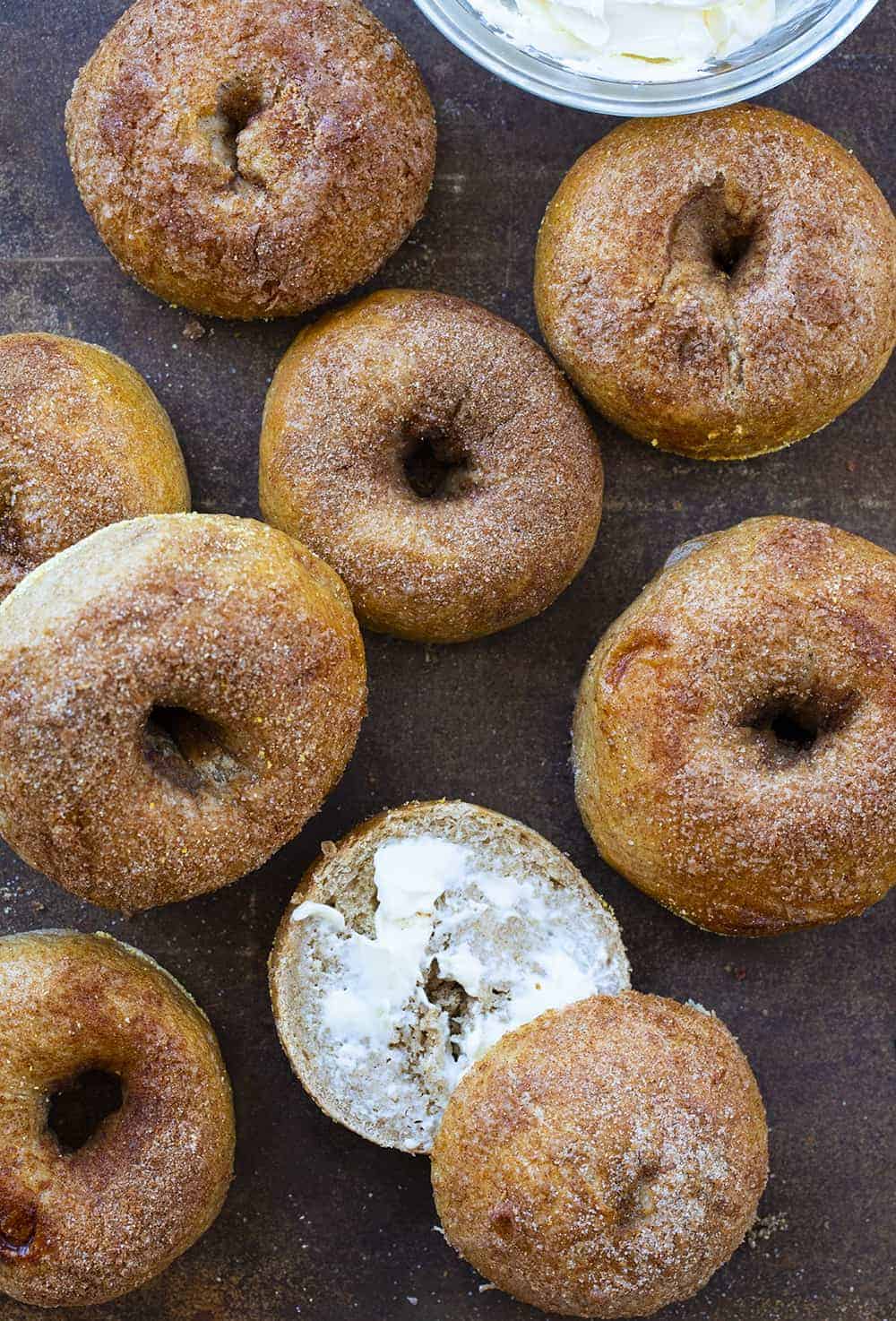 Overhead of Cinnamon Sugar Bagels with One Cut Open and Has Cream Cheese on It