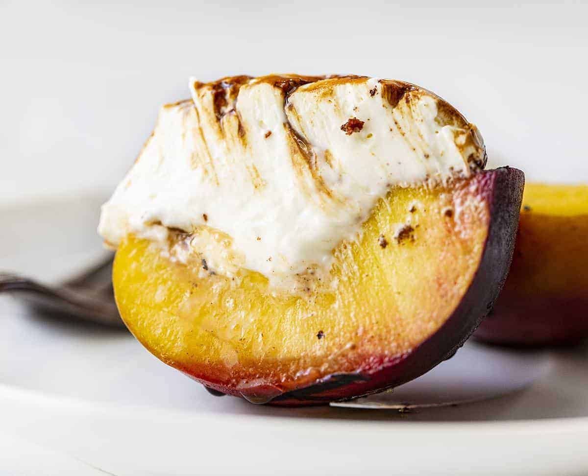 One Grilled Peach Cut in Half Showing How Juicy Inside Is