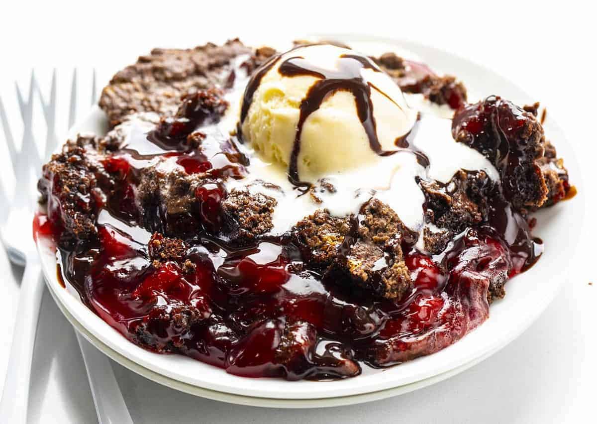 Piastra di Chocolate Cherry Dump Cake con gelato e due forchette bianche