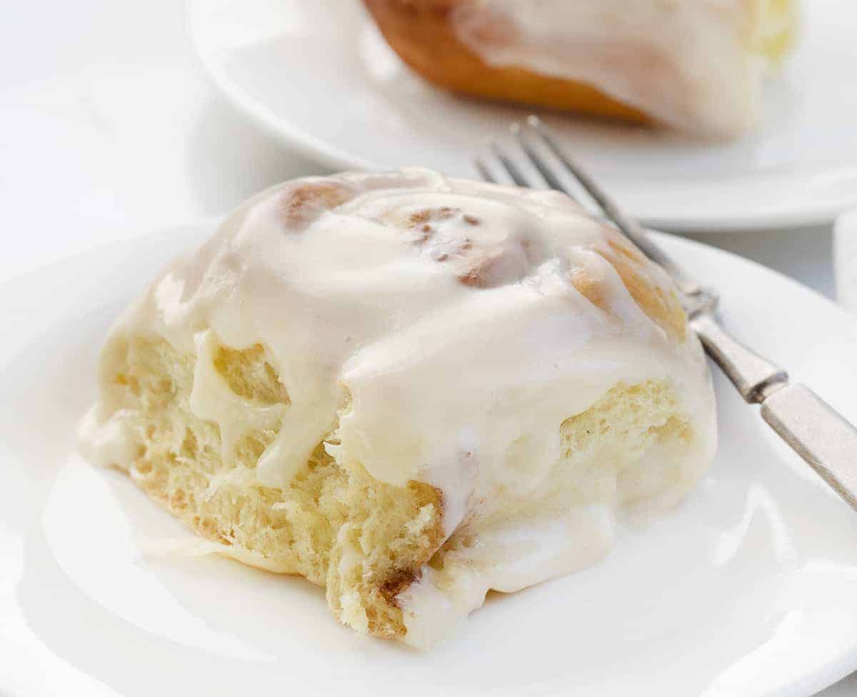 One Cinnamon Roll on a White Plate with Fork