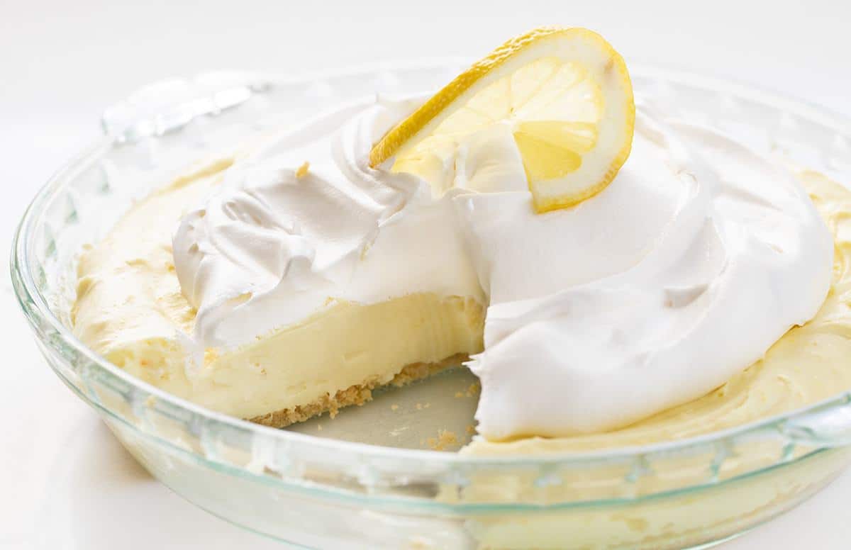 Lemonade Pie in glass pie dish with piece missing