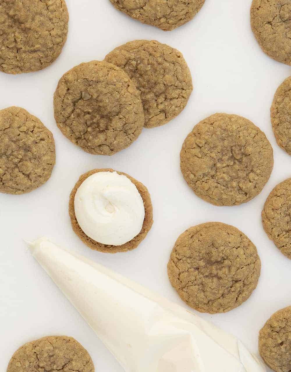 Overhead of Scattered Oatmeal Cream Pie Cookies with One Frosted with Buttercream