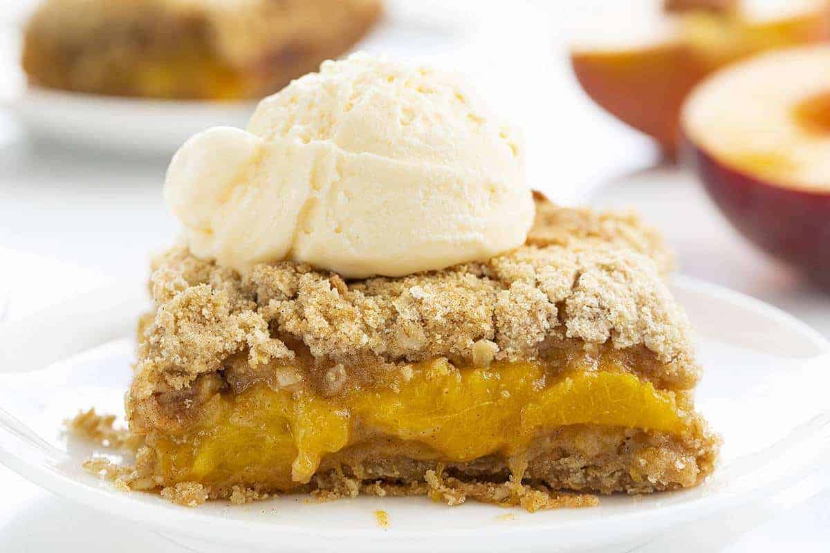 One Piece of Peach Crisp on White Plate with Ice Cream on Top