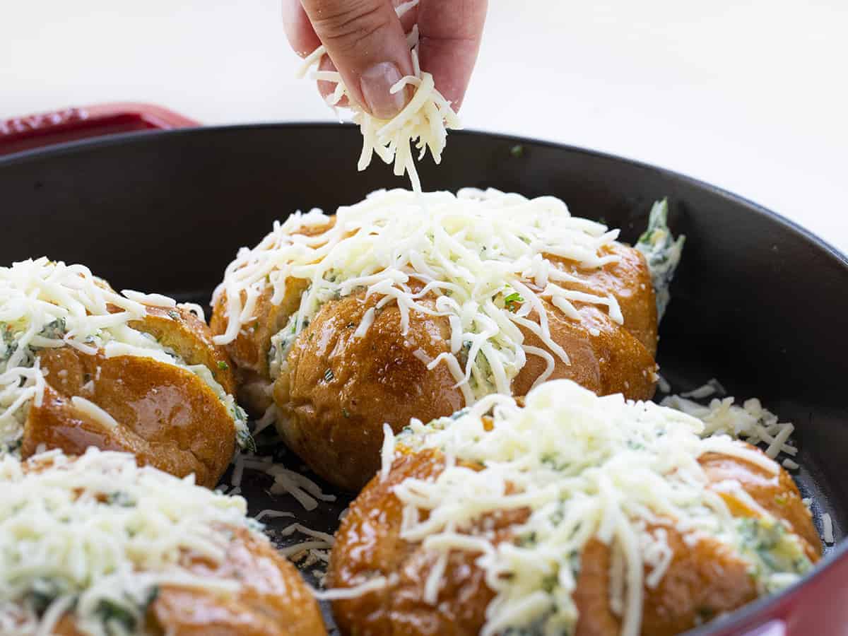 Sprinkling Cheese over Spinach Artichoke Pull Apart Bread