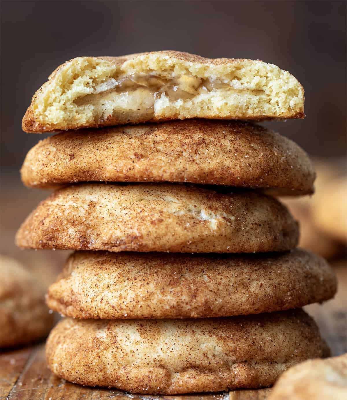 Stack of Apple Pie Snickerdoodles with the top cookie halved showing inside texture.
