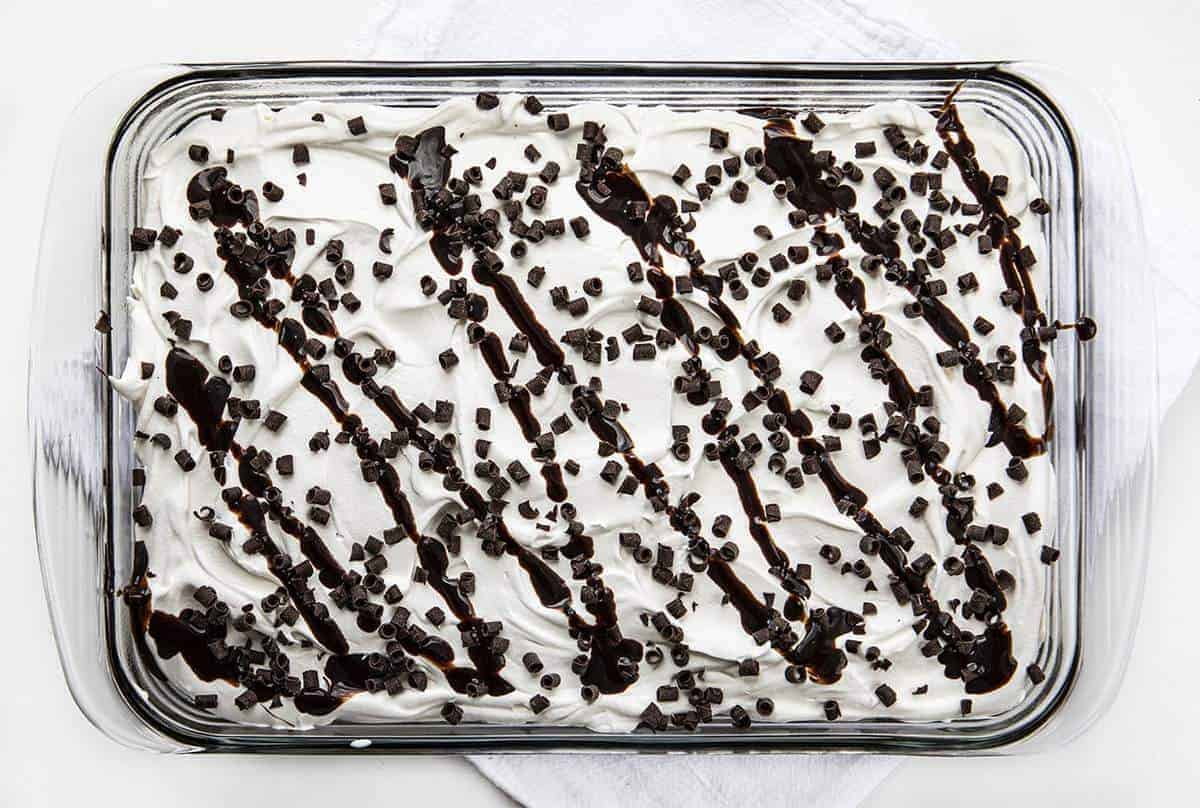 Overhead Image of Brownie Pudding Dessert Showing Chocolate Curls and Chocolate Syrup on Top of Whipped Cream