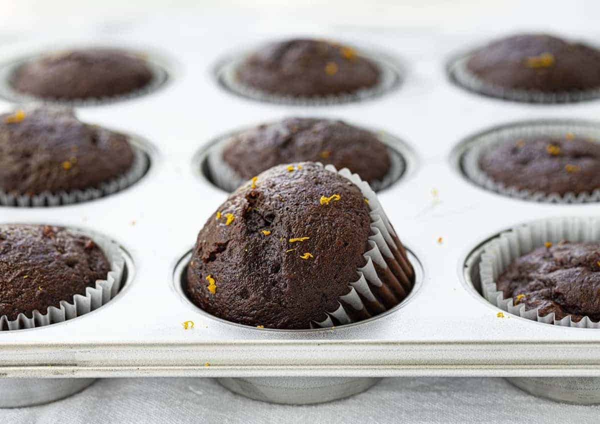 Pan of Chocolate Orange Muffins with One Titled on Its Side