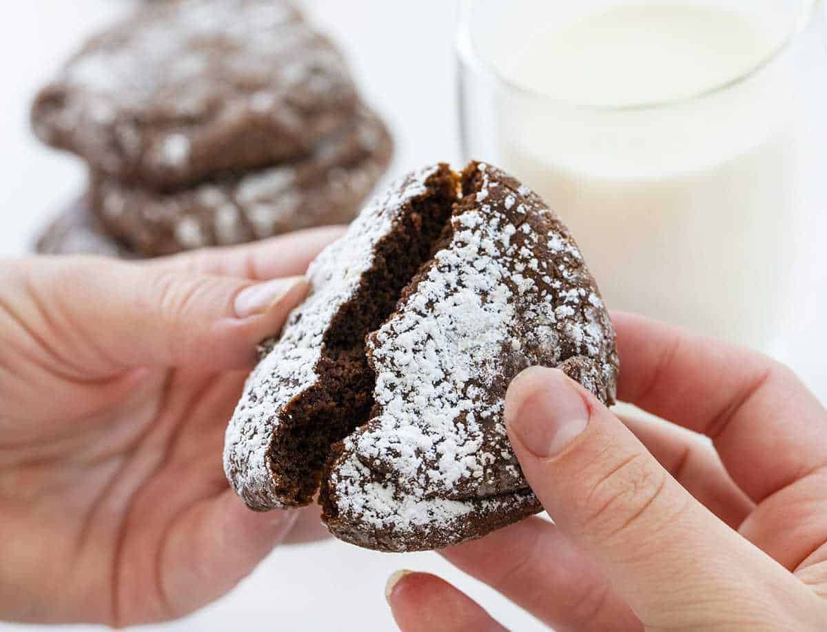 Hands holding and Breaking a Chocolate Ooey Gooey Cookie in Half