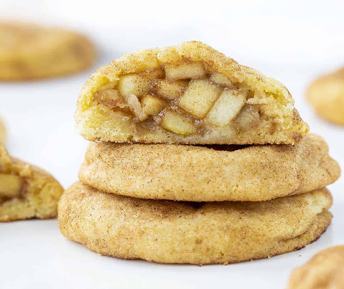 Snickerdoodles à la tarte aux pommes empilés avec le dessus coupé en deux pour montrer la tarte aux pommes à l'intérieur