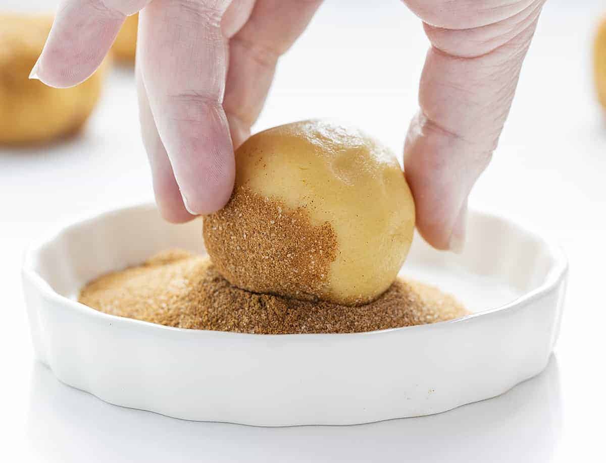 Enrouler la pâte à biscuits Snickerdoodle dans du sucre à la cannelle pour faire des Snickerdoodles à la tarte aux pommes