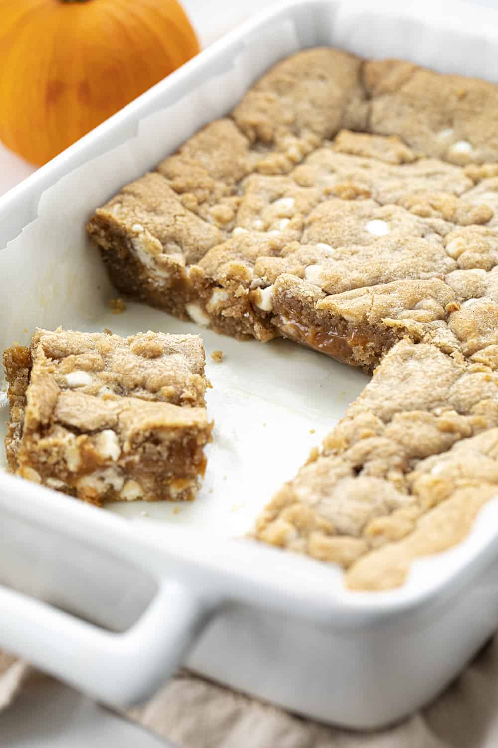 White Chocolate Pumpkin Spice Caramel Bars in a Pan with Some removed