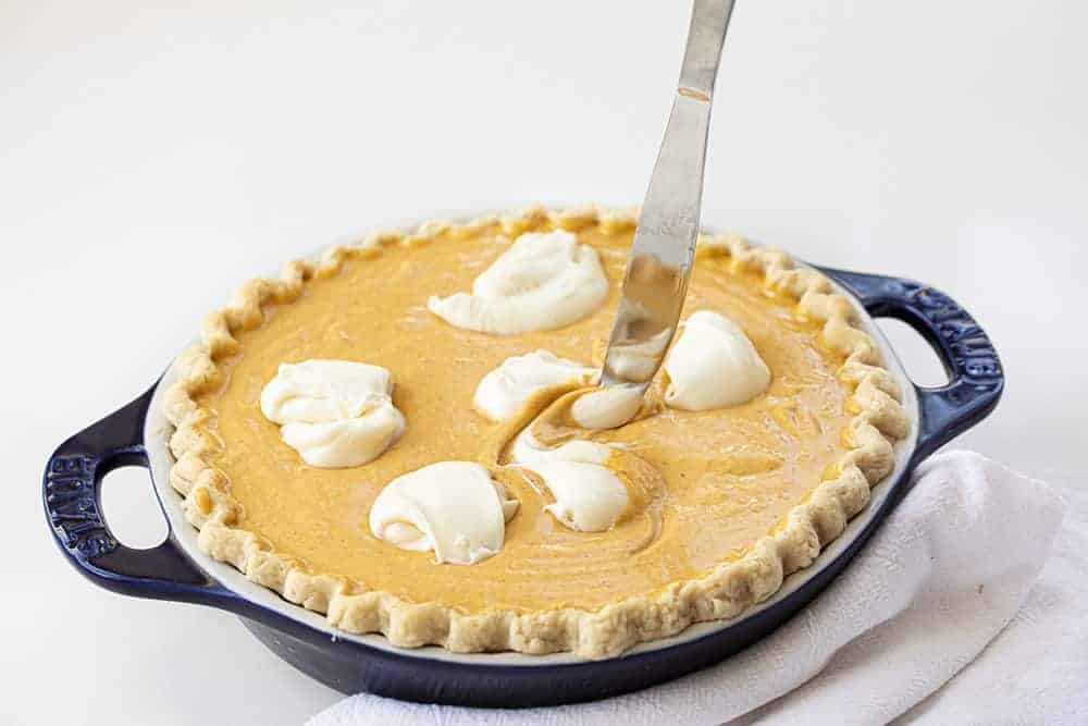 Knife Swirling Cream Cheese in a Pumpkin Cream Cheese Pie