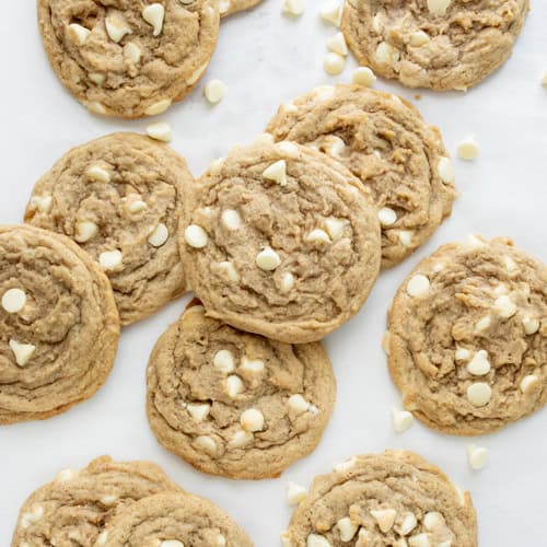 White Chocolate Pumpkin Spice Cookies on a White Counter with White Chocolate Chips from Overhead.