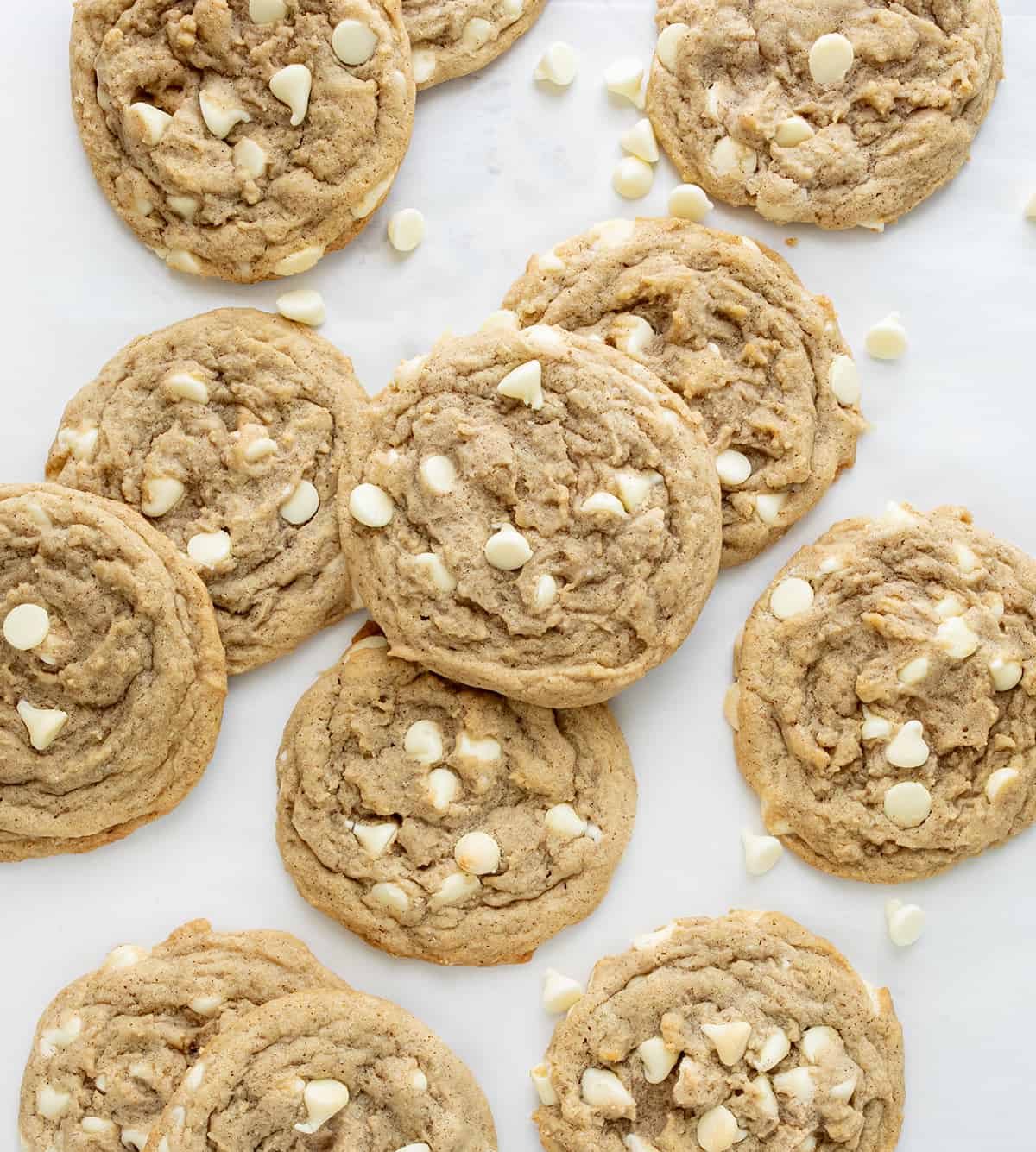 White Chocolate Pumpkin Spice Cookies on a White Counter with White Chocolate Chips from Overhead. 