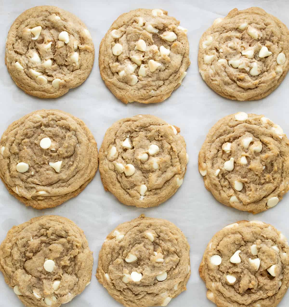 White Chocolate Pumpkin Spice Cookies on White Parchment Paper After Baking.