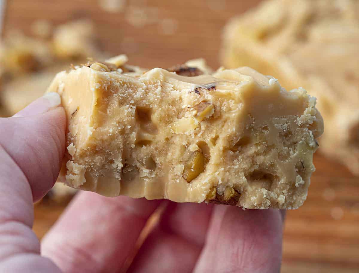 Hand Holding Bit Into Maple Walnut Fudge 