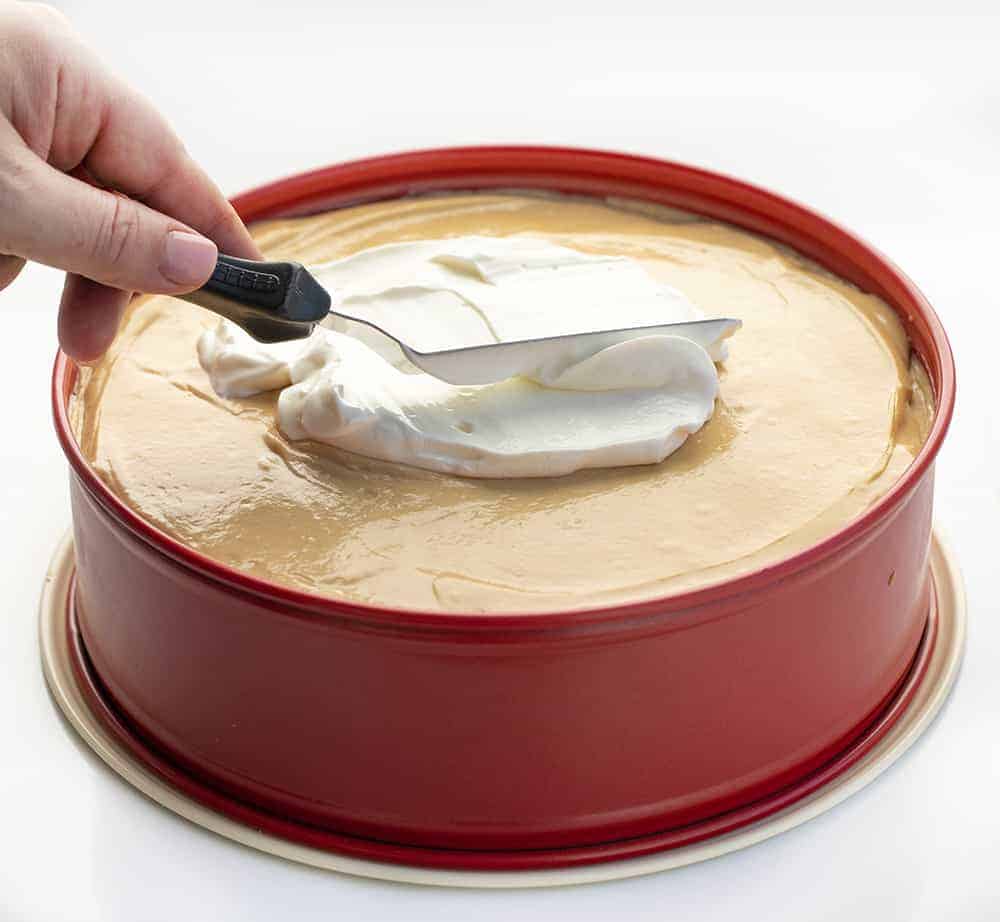 Spreading Sour Cream on Peanut Butter Cheesecake