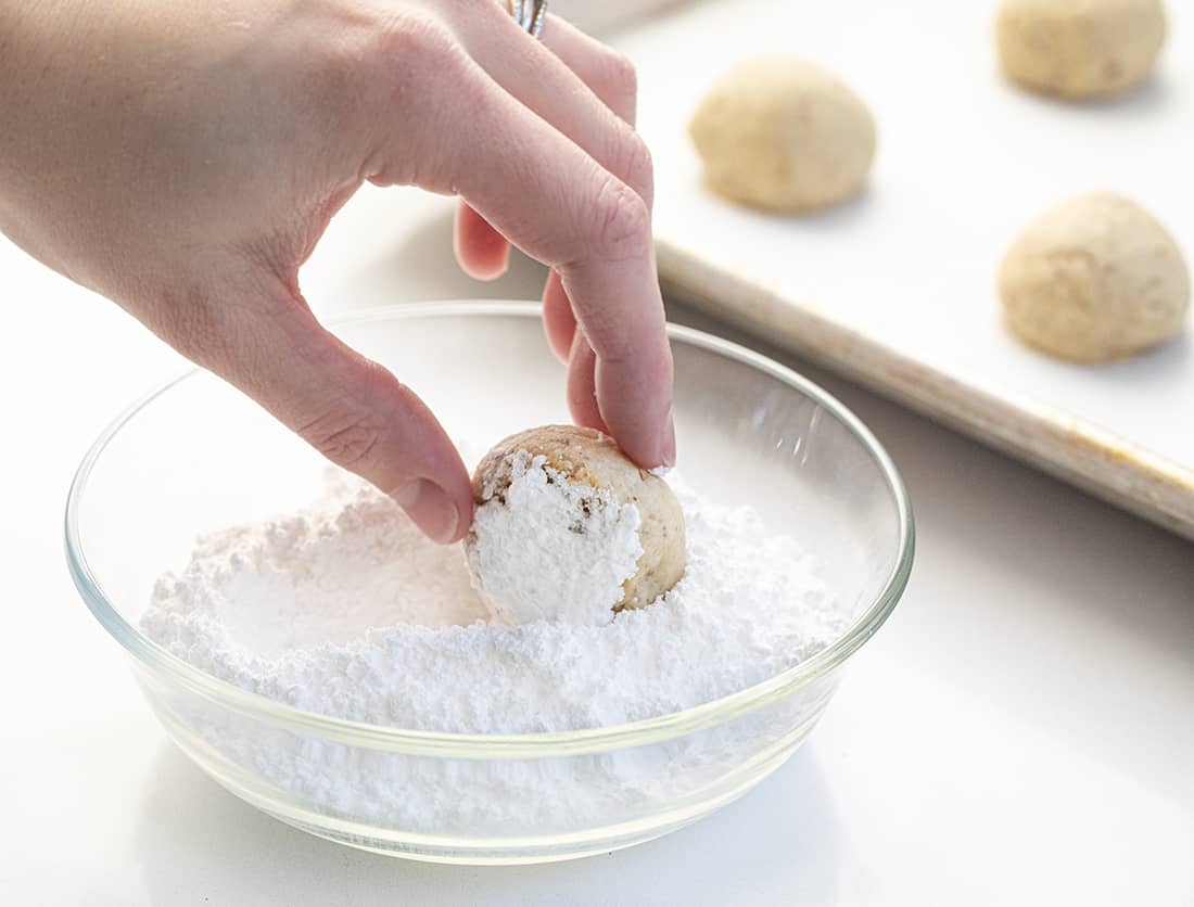 Snowball Cookies - Mexican Wedding Cookies Recipe Being Rolled in Confectioners Sugar