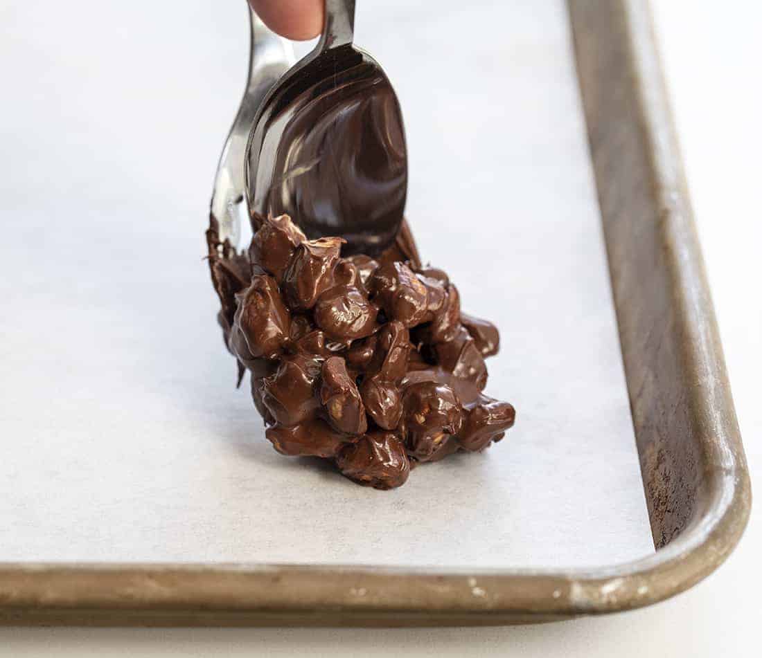 Chocolate Peanut Clusters Being Spooned onto Tray