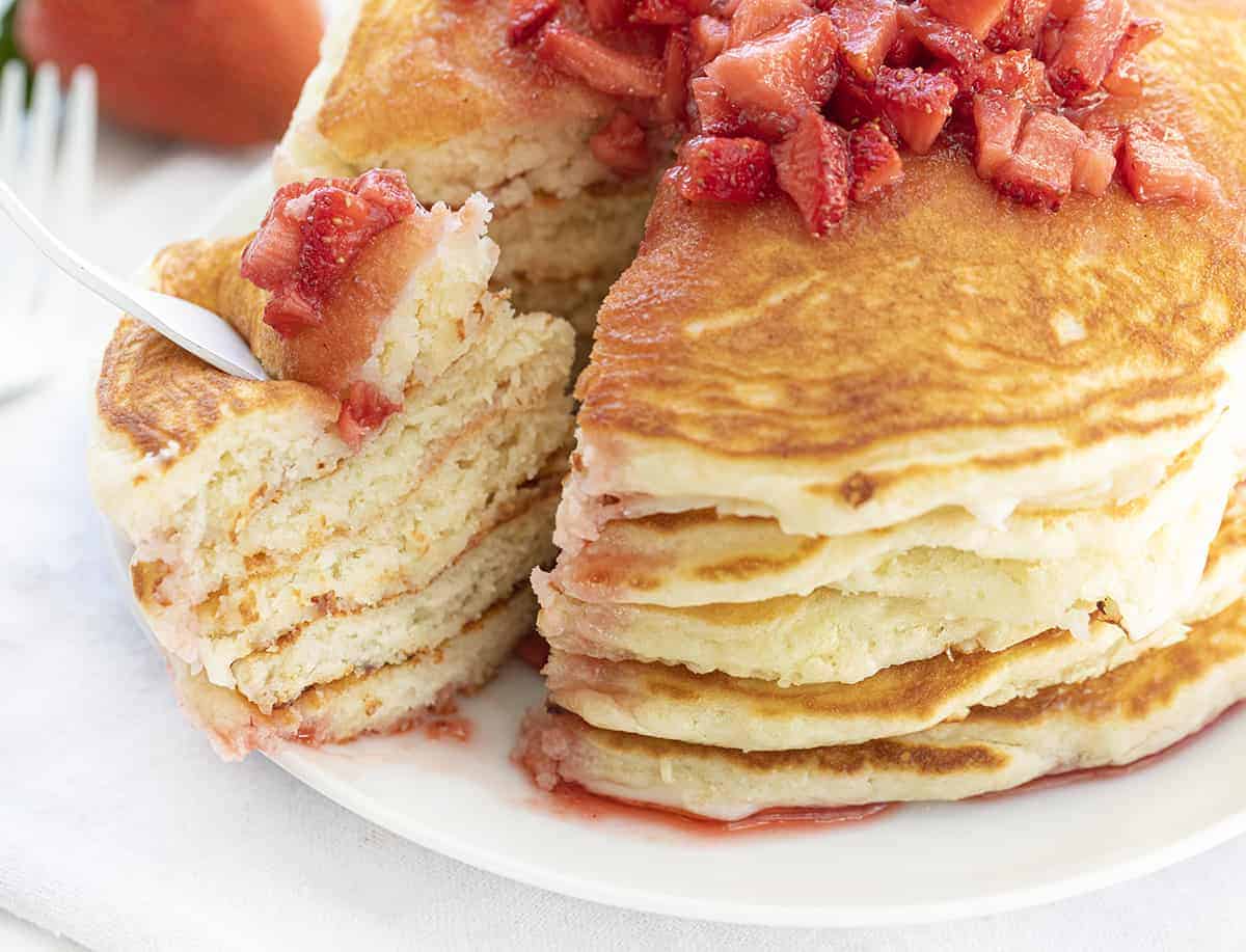 Fork Taking Bite from Strawberry Cheesecake Pancakes