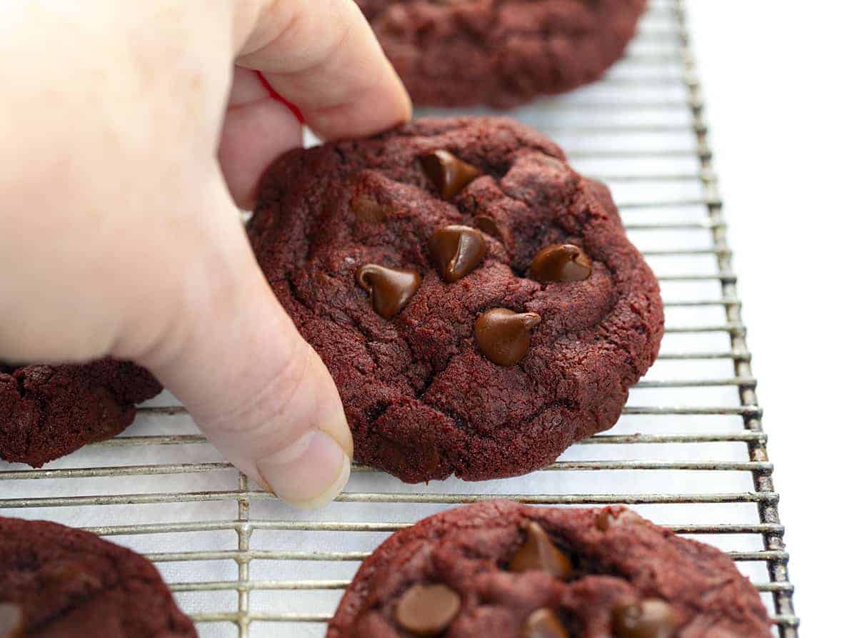Hand Picking Up Red Velvet Chocolate Chip Cookie