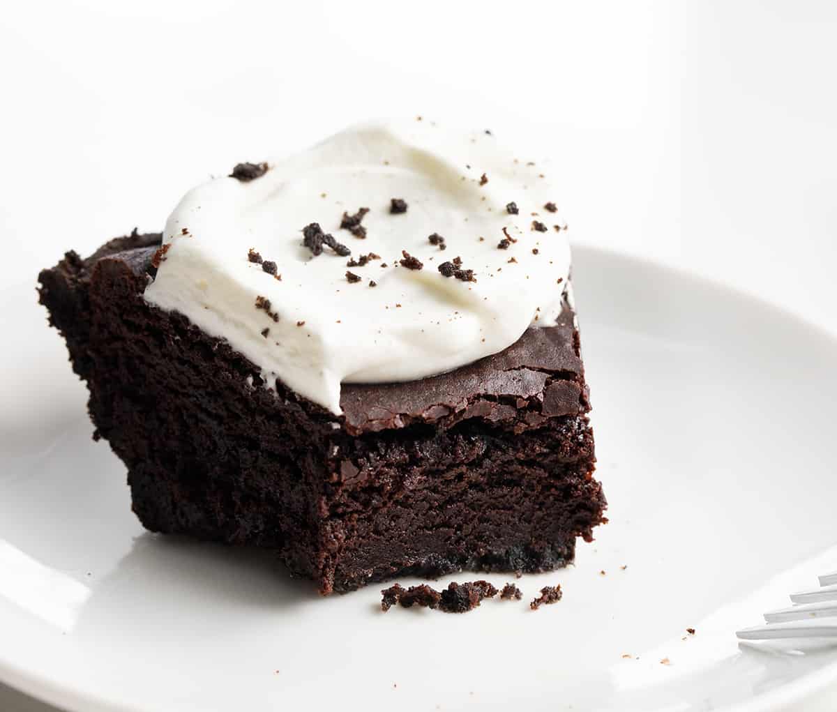 Piece of Brownie Pie on a White Plate with Bite Removed Showing Inside Texture.