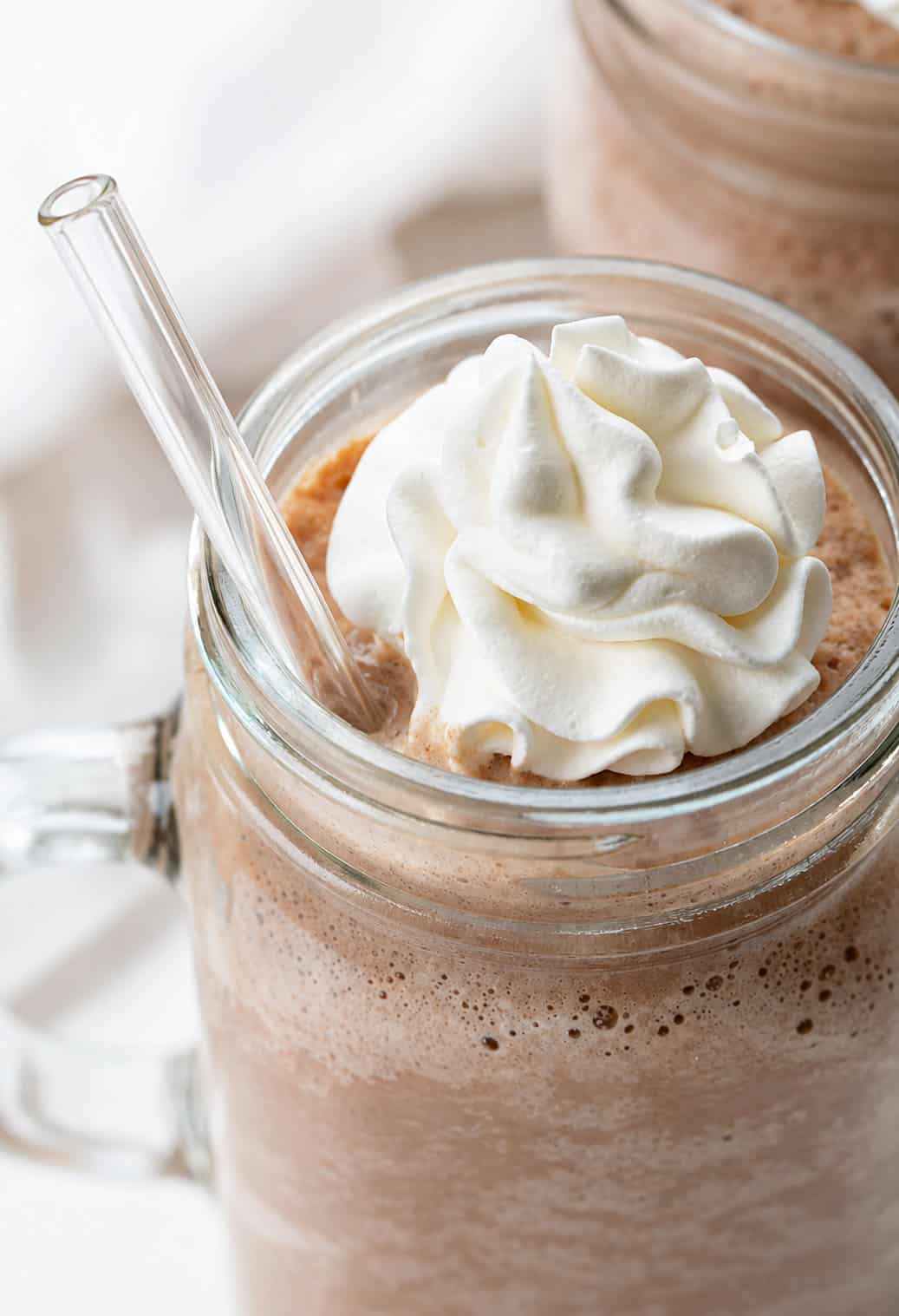 Close up of a glass of Frozen Hot Chocolate with a glass straw.