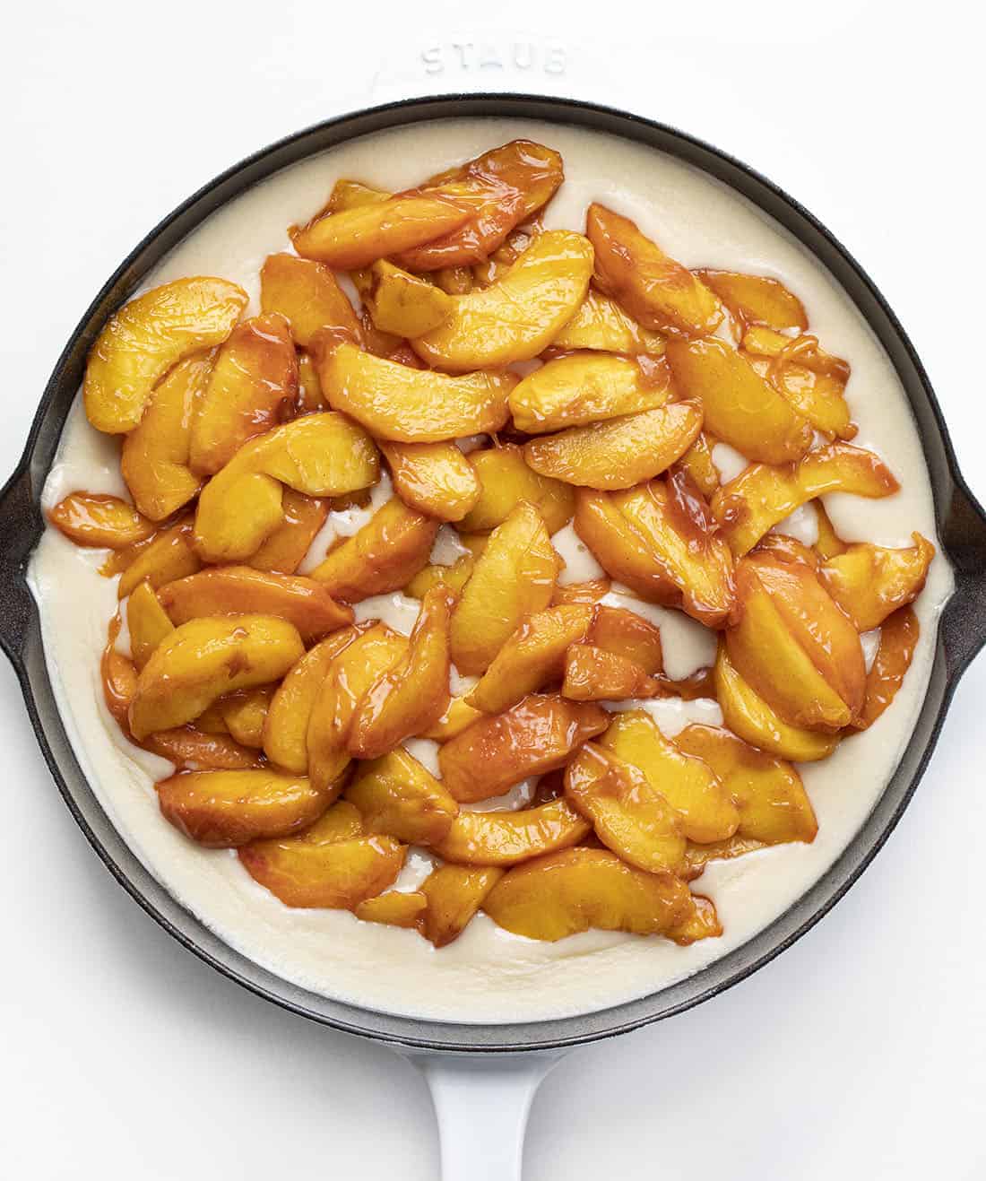 Adding Peaches to Batter in White Skillet