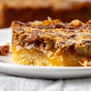 Close up of Pecan Pie Shortbread Bar on a plate with a bite removed.