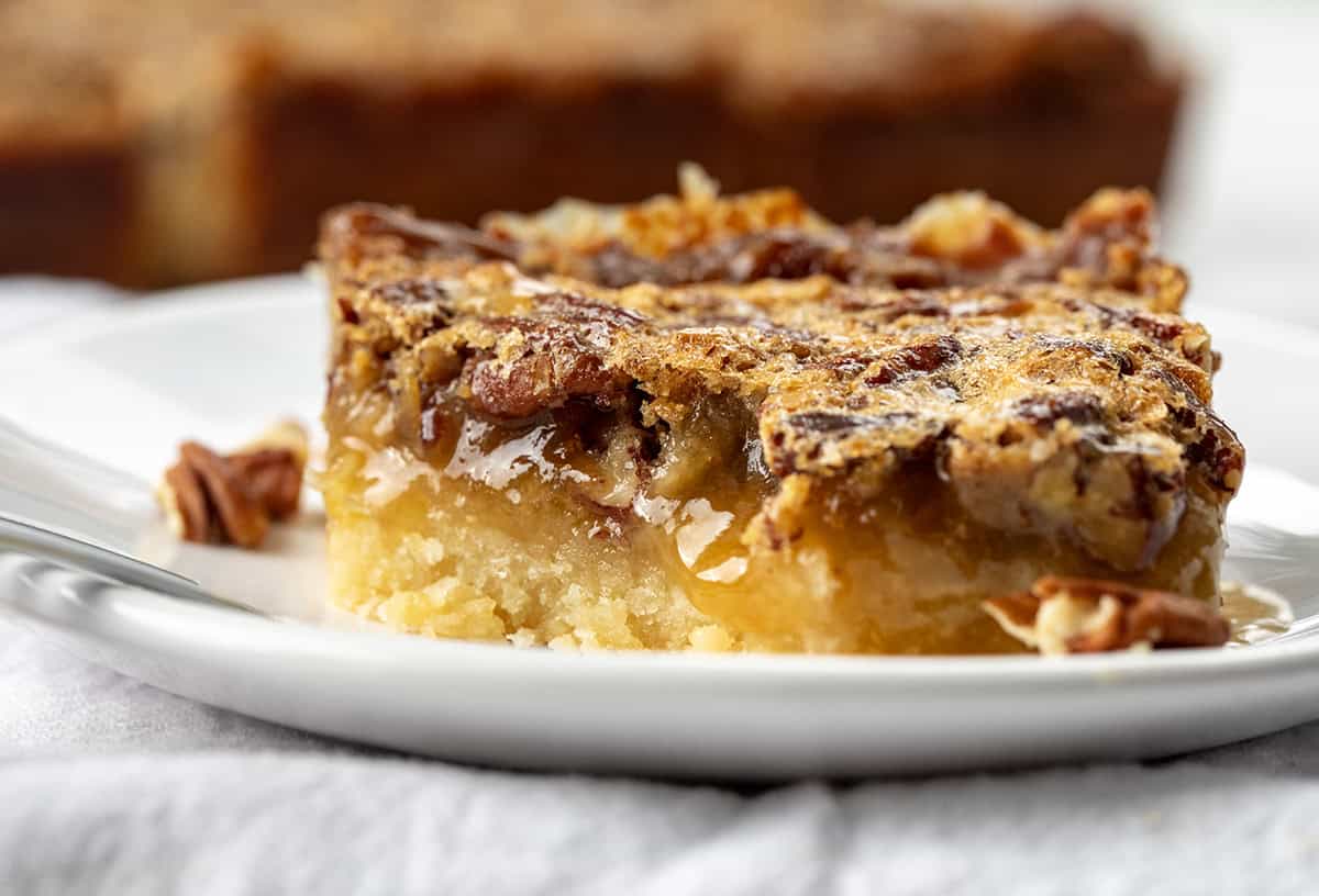 Close up of Pecan Pie Shortbread Bar on a plate with a bite removed.