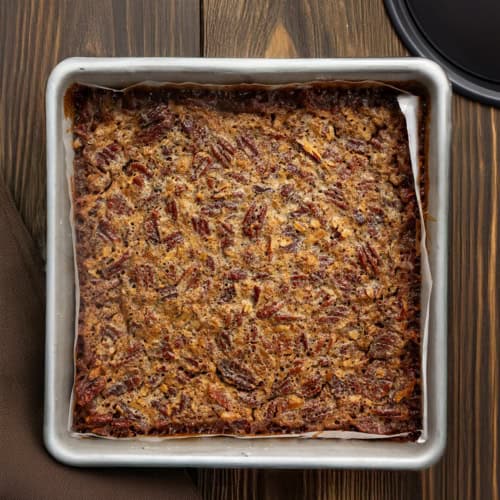 Pan of Pecan Pie Shortbread Bars on a wooden table from overhead.