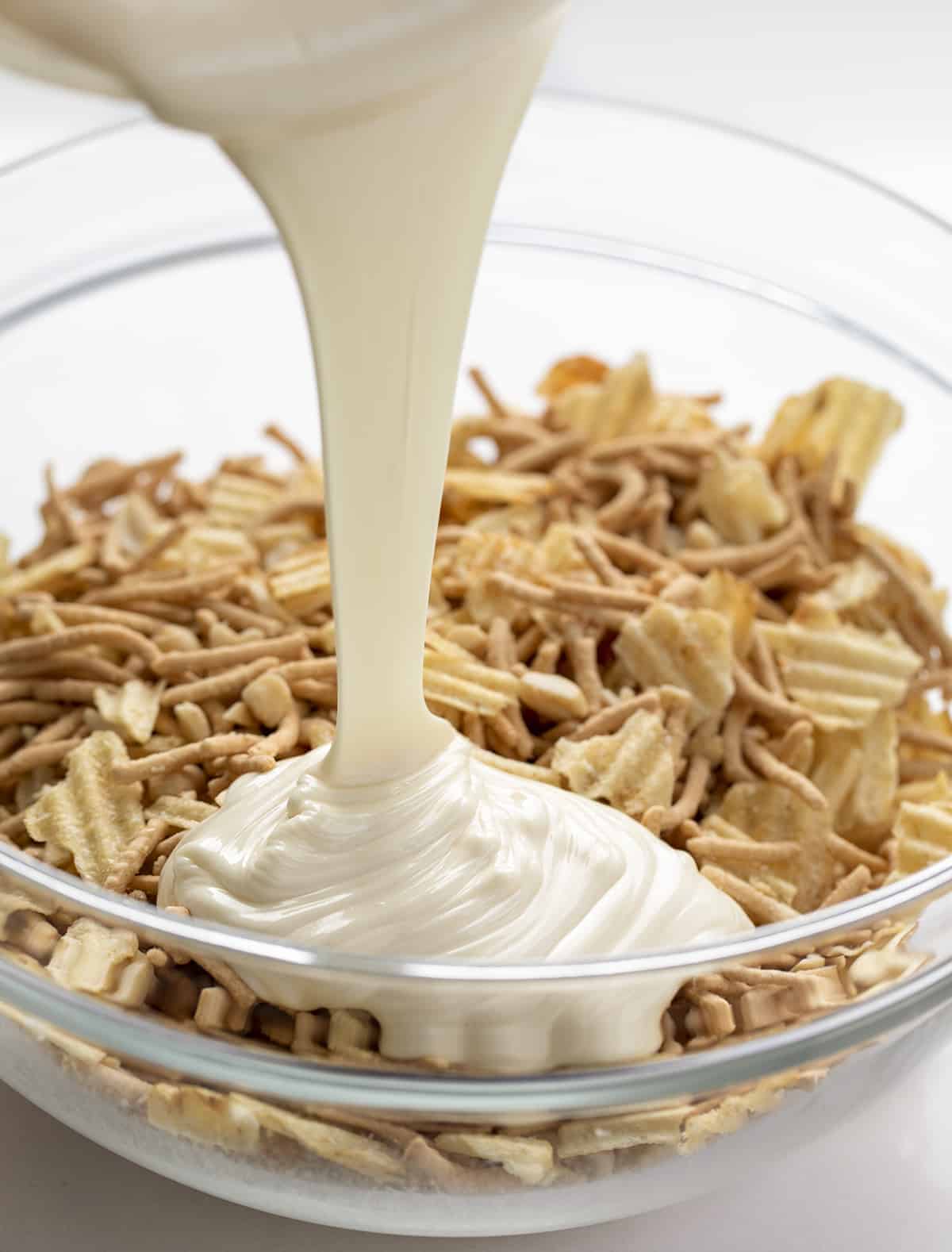 Pouring Almond Bark over ingredients for Haystack