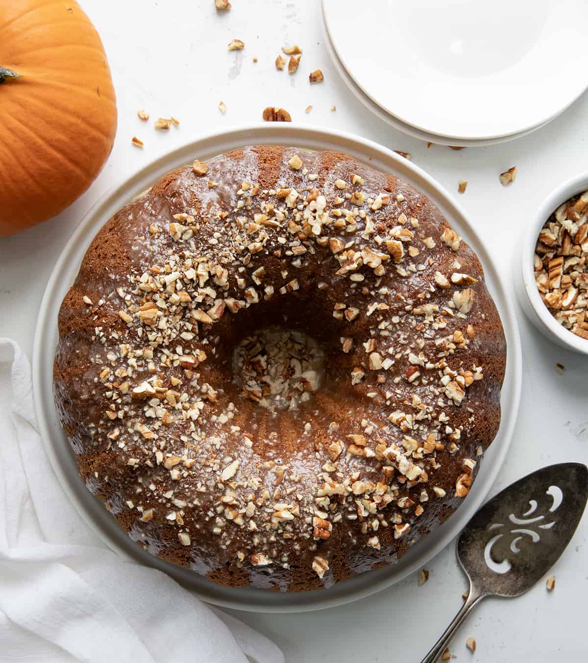 Overhead of a Pumpkin Spice Bundt Cake on a White Table.