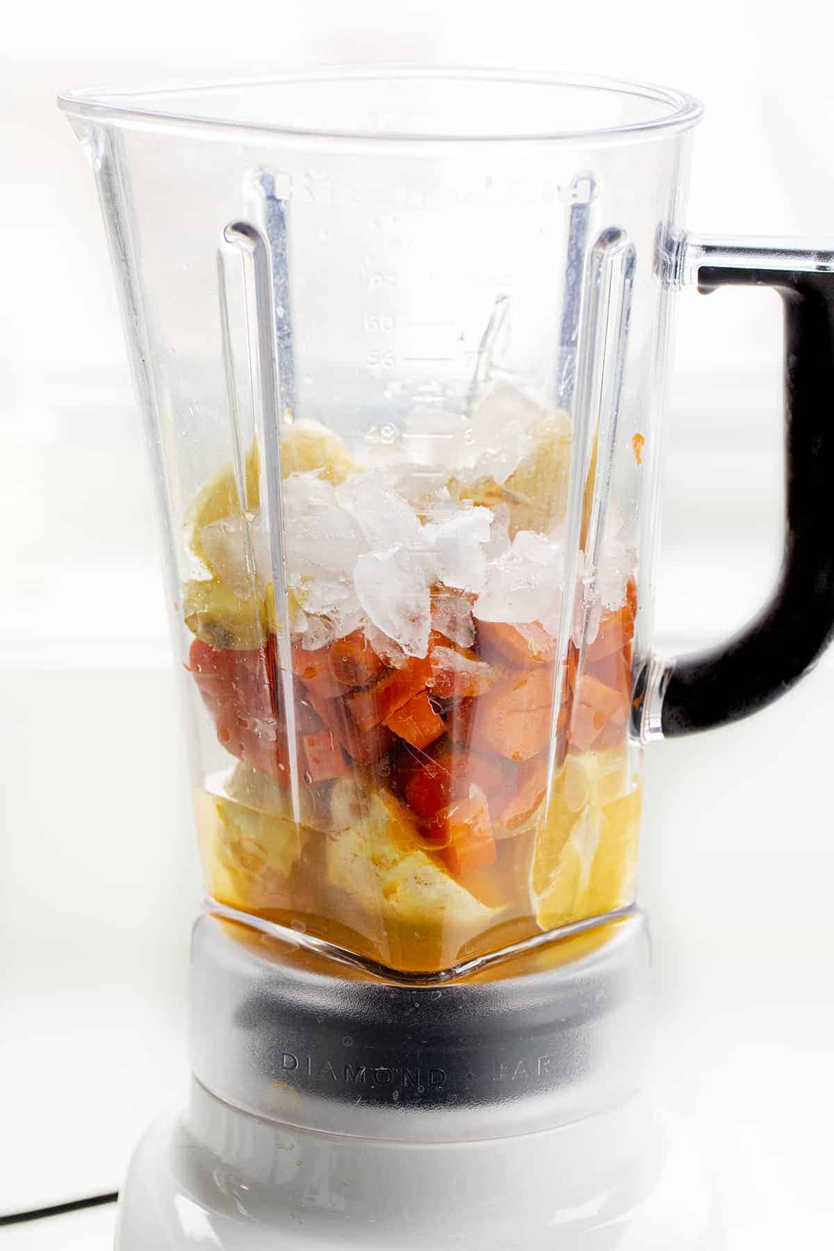 Blender with Raw Ingredients for Orange Smoothie