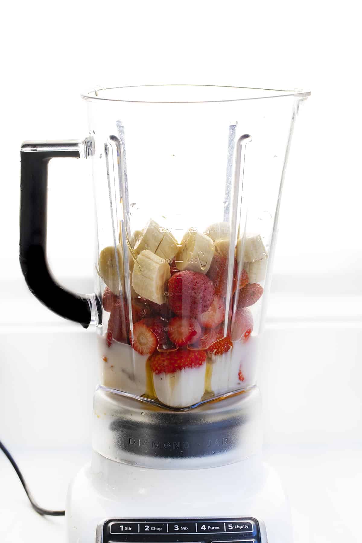 Blender Filled With Ingredients for Strawberry Banana Smoothie 