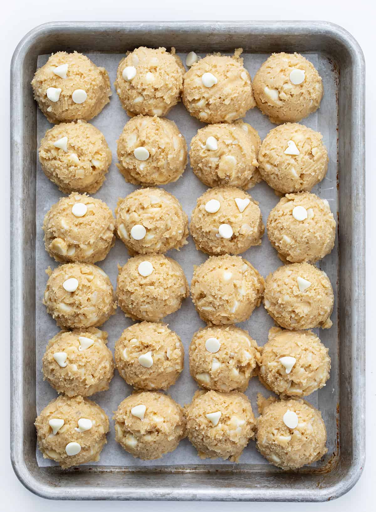 Raw White Chocolate Macadamia Nut Cookie Batter in Scoops on a Baking Sheet.