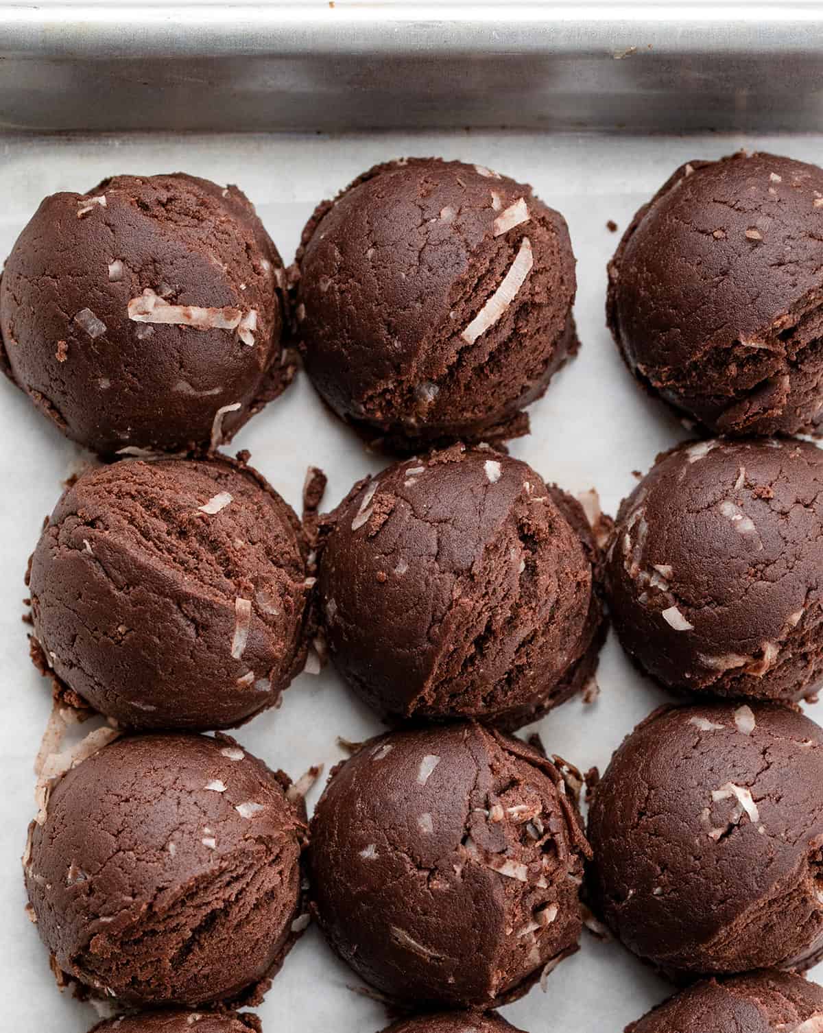 Scoops of German Chocolate Cookie Dough on a cookie sheet.