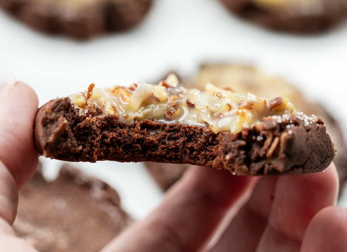 Hand holding a bit into German Chocolate Cookie.