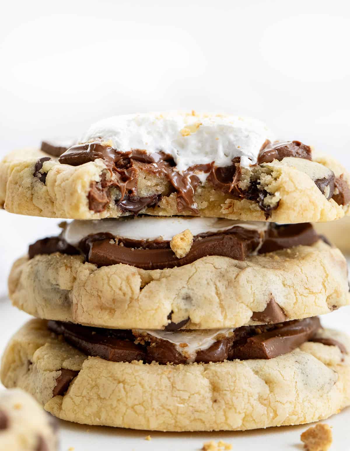 Stack of S'mores Cookies with top cookie bit into showing inside texture. 