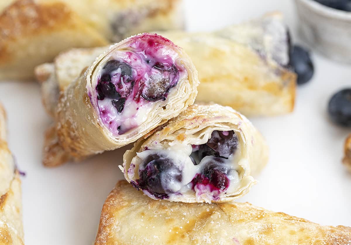 Cut Into Blueberry Cheesecake Egg Rolls Showing Creamy Inside. Dessert Egg Rolls, Dessert, Egg Rolls, Egg Roll Recipes, Blueberry Cheesecake, Cheesecake, Snacks, Dessert Appetizer, Hot Dessert, Blueberry Desserts, Summer Desserts, How to Make Cheesecake Egg Rolls, Recipes, i am baker, iambaker