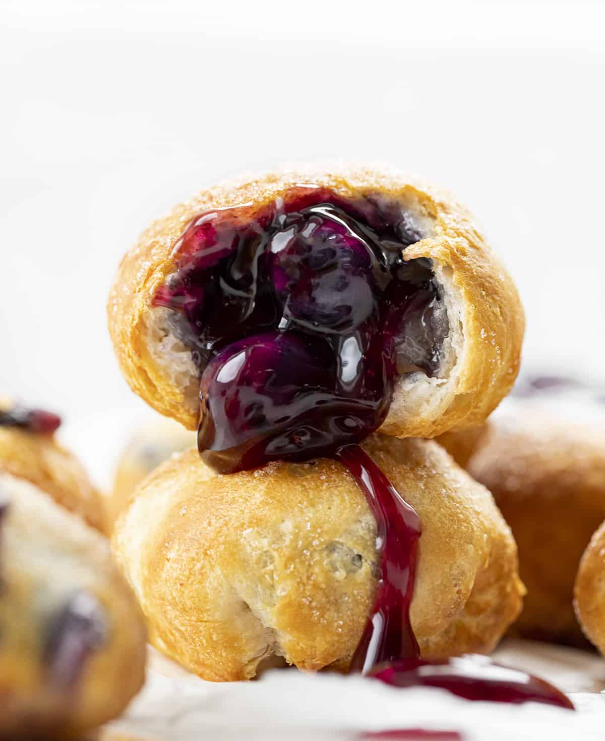 Stacked Blueberry Pie Bombs with One Cut in Half and Blueberry Pie Filling coming out. Breakfast, Blueberry Pie Bombs, Fruit Filled Hand Pies, Air Fryer Recipes, Blueberry Breakfast, Baked Blueberry Desserts, Dessert, Cherry Pie Bombs, Baked Pie Bombs, recipes, i am baker, iambaker