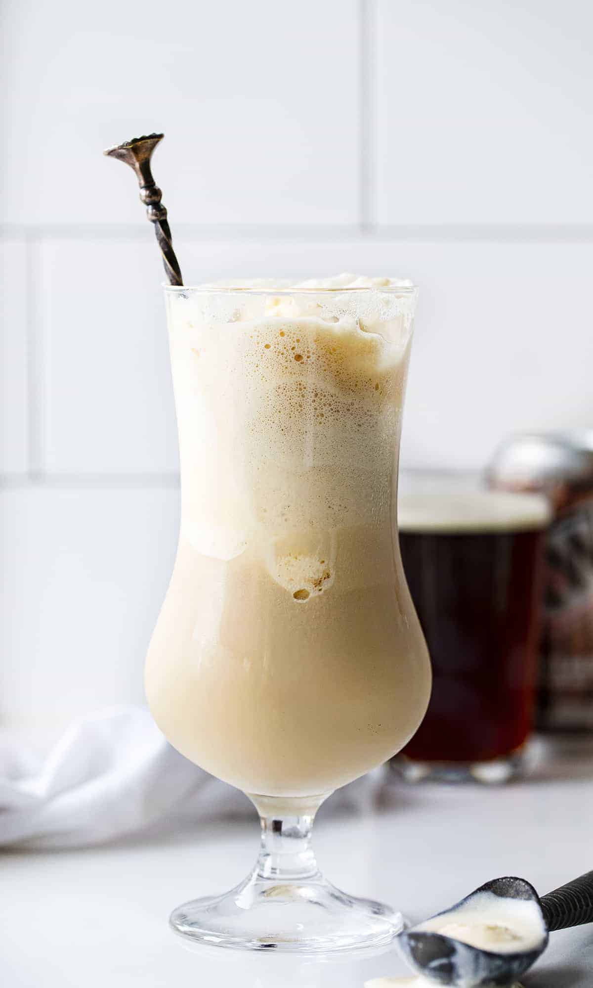 Dirty Root Beer Float - RumChata Root Beer Float in a Glass with Ice Cream Scoop on Counter Next to It. 