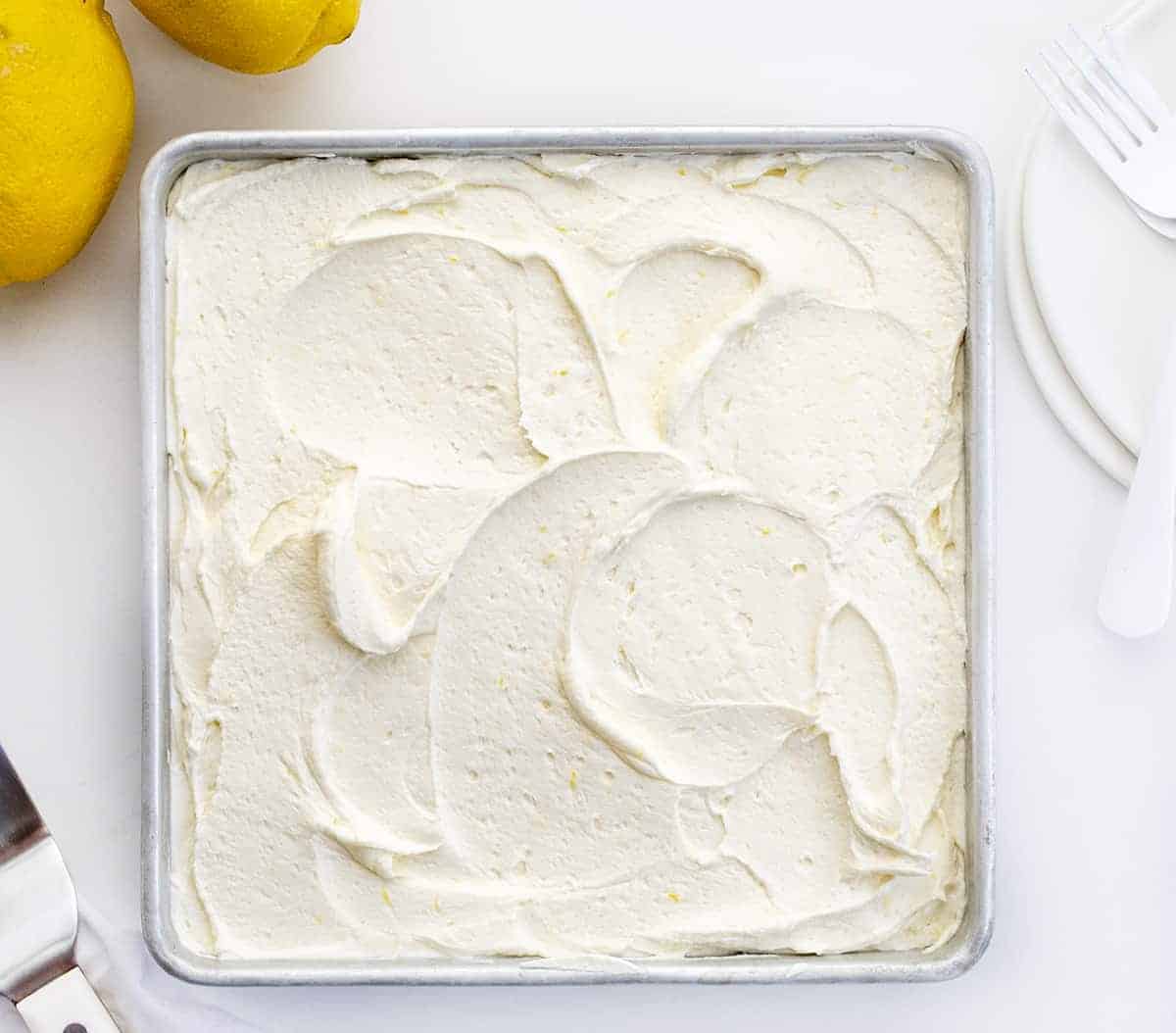 Pan of Lemon Crazy Cake with Lemon Buttercream Frosting in Swirls from Overhead.