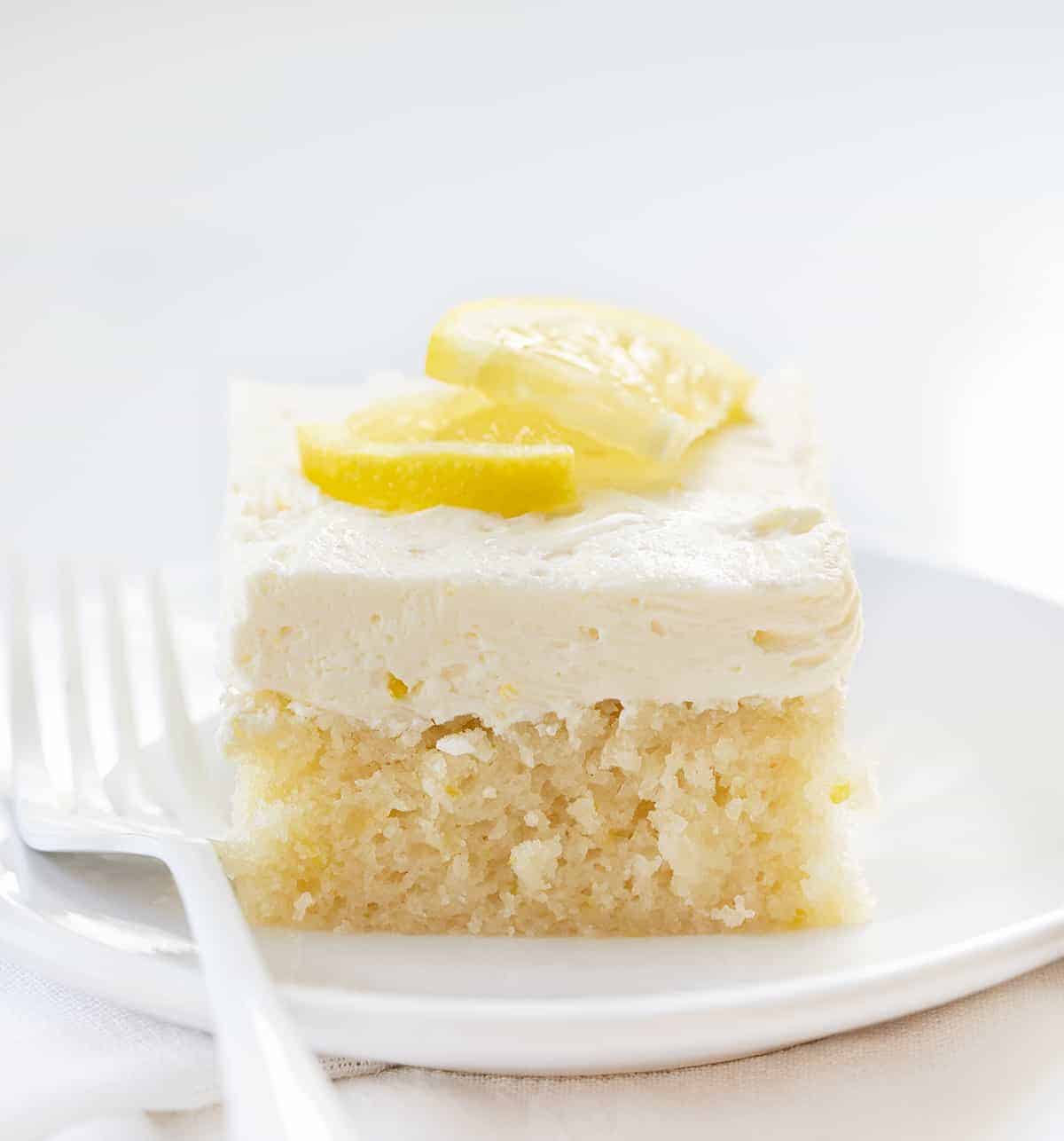 One Piece of Lemon Crazy Cake on a White Plate with White Fork.